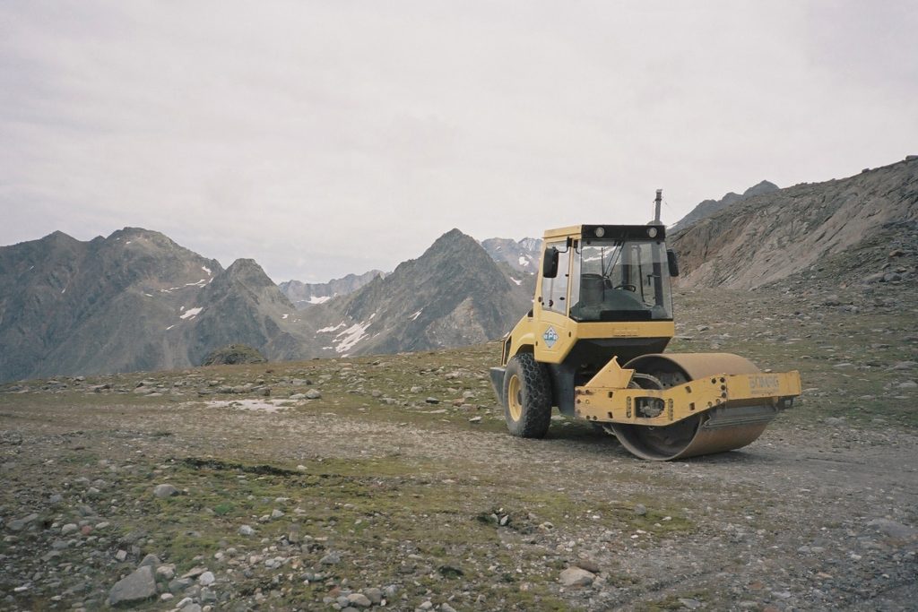 Gelbe Strassenwalze vor Bergpanorama
